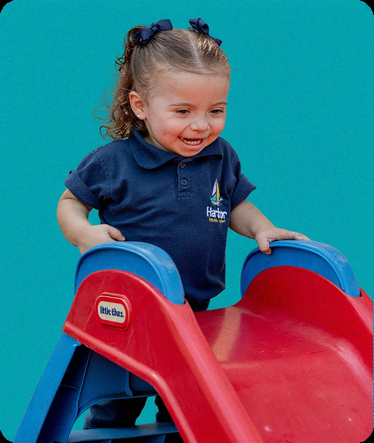 Child playing on a slide at Harbor Preschool Academy