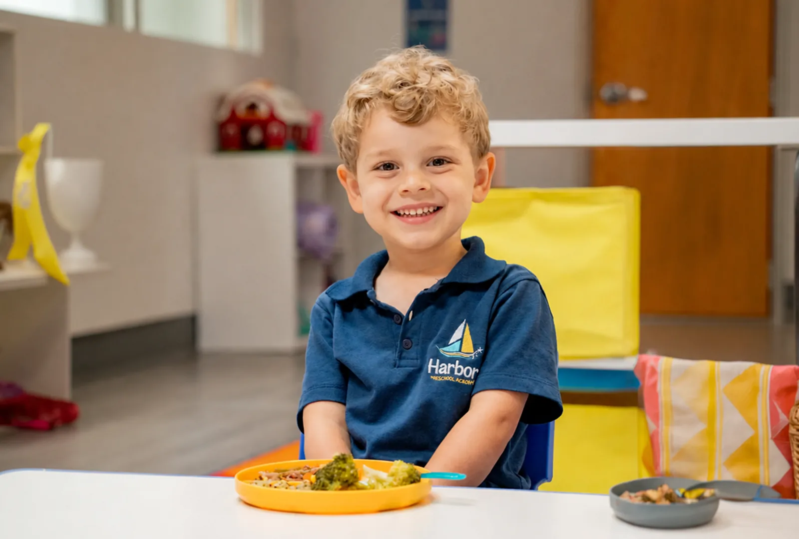 Boy smiling at a table with a balanced meal